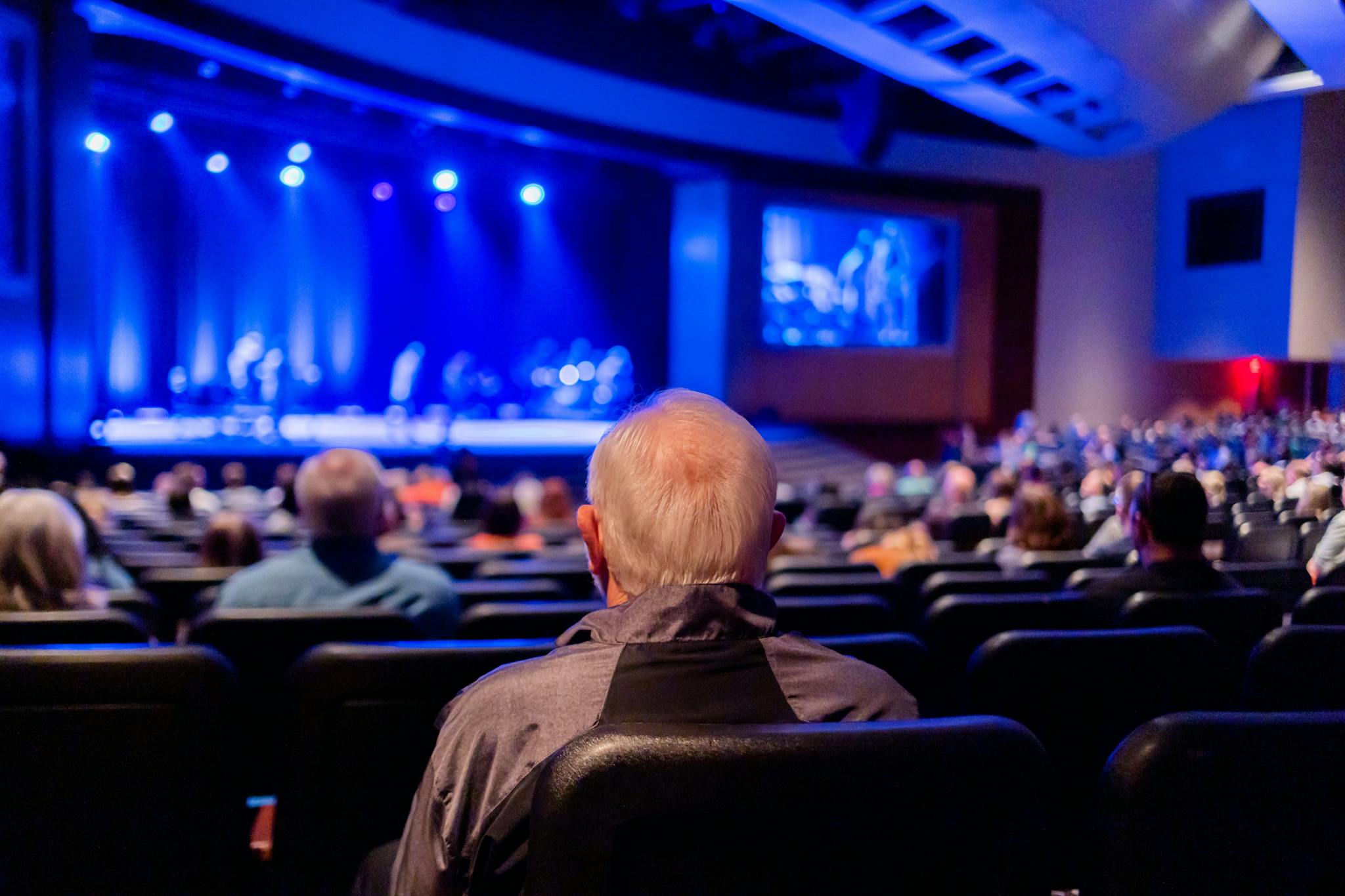 Audience seated in a theater watching a captivating live performance on stage.
